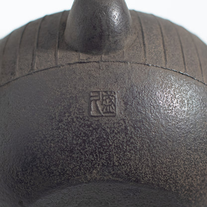 Iron Kettle with Vertical Stripe Pattern and Flat Circular Shape